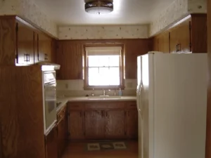 Cramped U-shaped kitchen with obtrusive appliances jutting into the space.