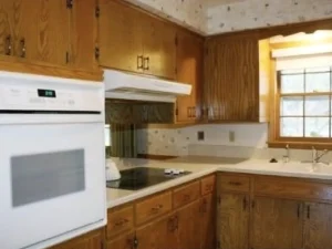 Kitchen corner with original dated golden oak cabinetry.